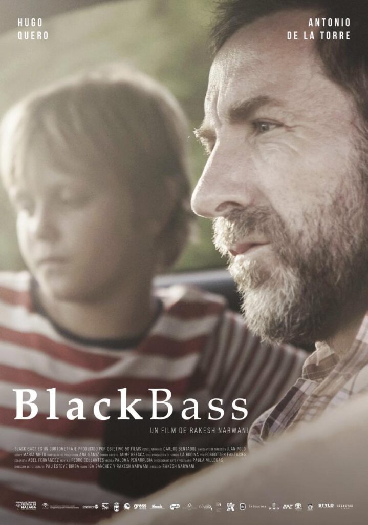 Cartel del cortometraje Black Bass. Aparece en primer plano Antonio de la Torre que representa a un padre y de fondo vemos a su hijo desenfocado con pelo rubio y camiseta de líneas horizontales rojas.
