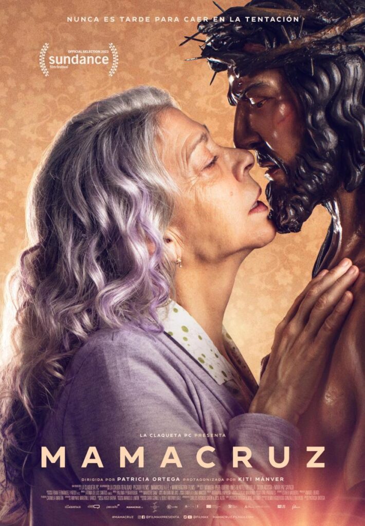 Cartel del largometraje Mamacruz. Señora de 65 años (kiti Manver) acercándose a una figura de imaginería en madera que representa a Jesucristo para darle un beso en la boca.