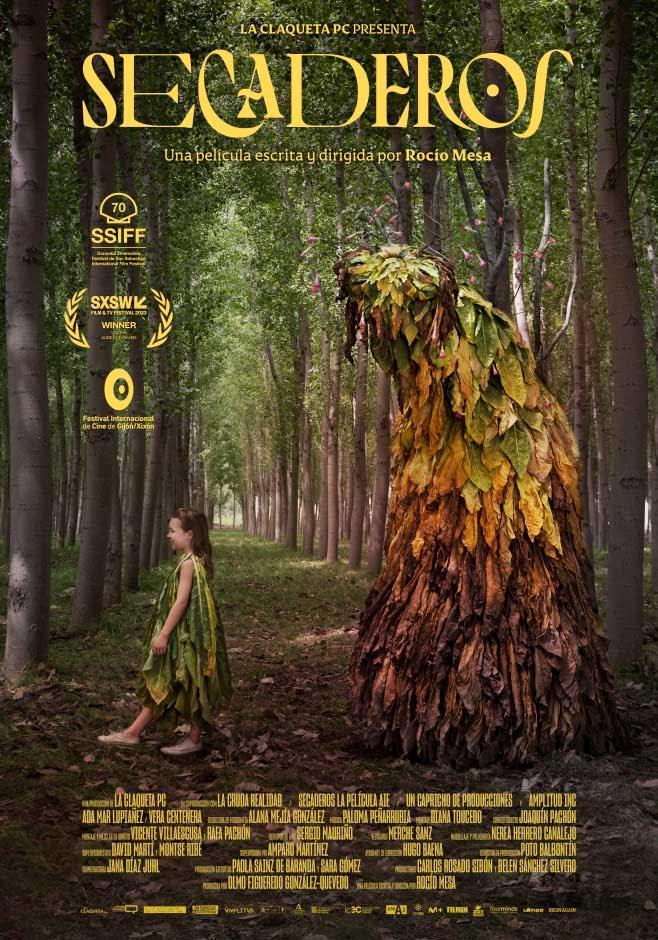 Cartel del largometraje Secaderos. Fotografía de una niña de 8 años vestida con hojas de tabaco acompañada de una criatura mágica de hojas de tabajo. Caminan sobre un bosque de álamos.